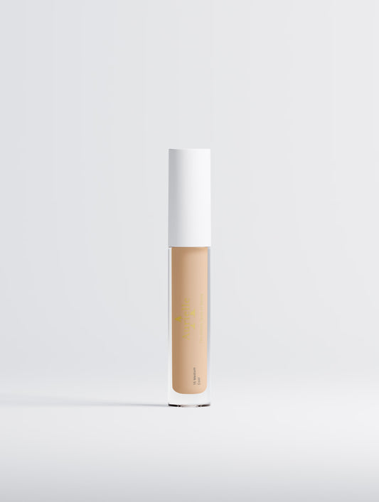 Cosmetic concealer stick with white cap on a light gray background